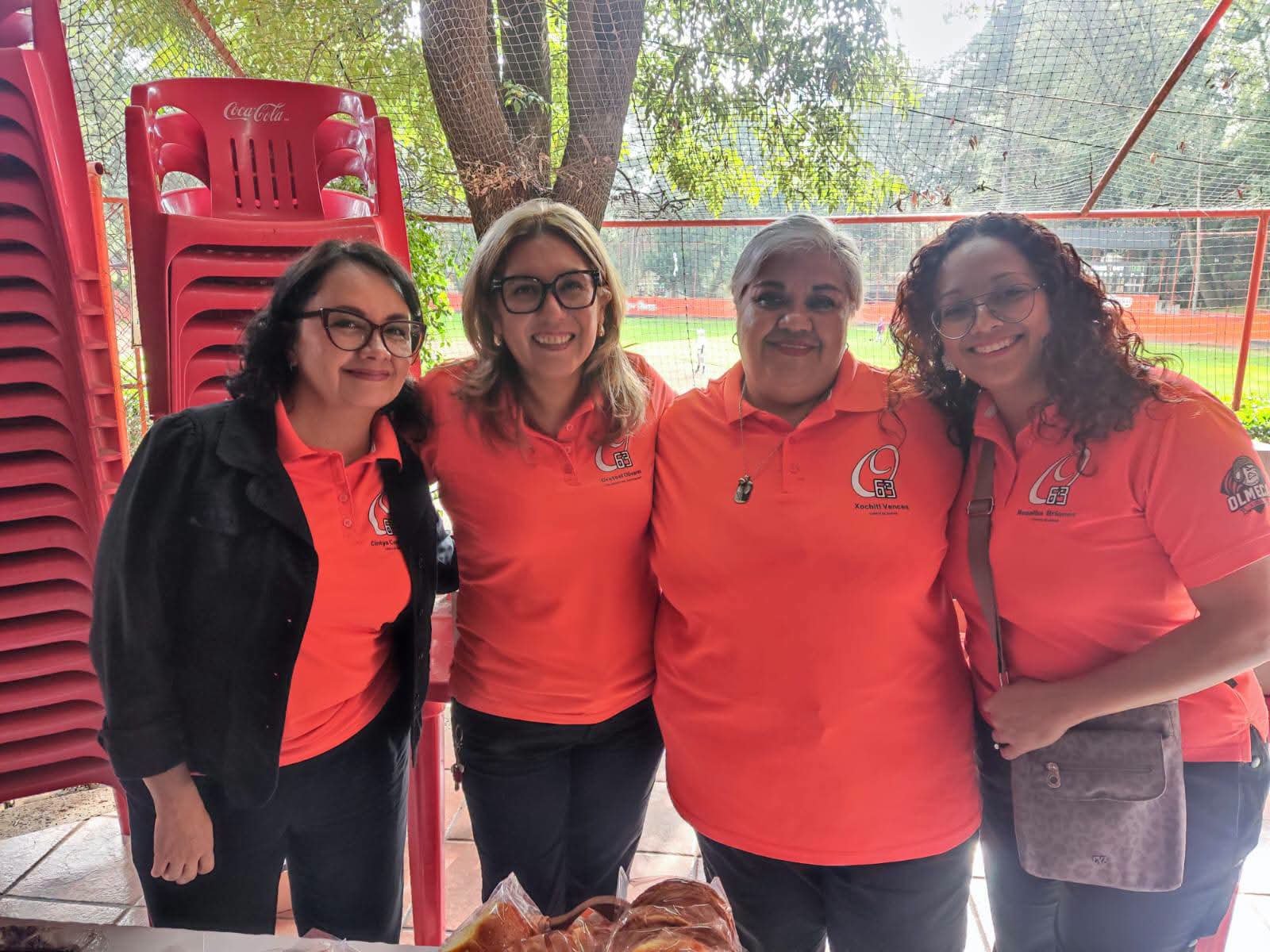 Cuatro integrantes de la comunidad junto al campo.